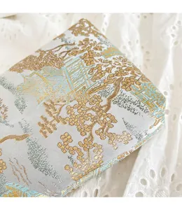 Close-up of exquisite Chinese embroidery on blue silk mini crossbody bag with landscape patterns