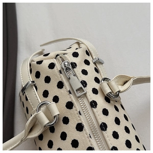 Detail van zilveren rits en hardware op canvas polkadot schoudertas dames