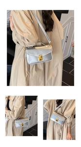 Detail view of silver patent leather crossbody bag with gold hardware and chain strap