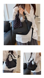 Détail du sac seau noir en cuir grainé avec finitions dorées et foulard à pois