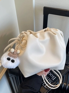 Chic beige ruched cloud bucket bag with cute fur pompom charm and fashion logo print