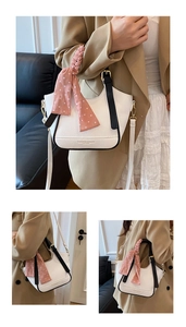 Détail du sac à main en cuir litchi blanc avec foulard rose à pois sur l'anse
