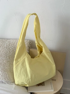 Minimalist large pale yellow tote bag on a wooden table for casual commute