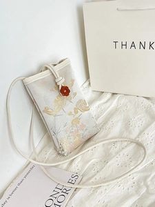Crossbody mini phone bag with floral patterns on cream fabric and vintage flower clasp