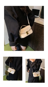 Detail view of cream white PU leather bag showing gold square lock and premium texture