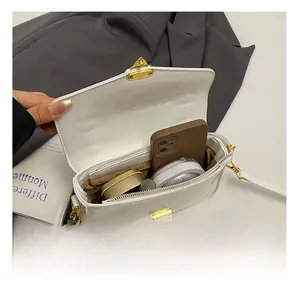 Interior view of white patent leather small square bag with phone and lipstick items