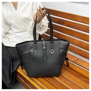 Detail of black pebbled leather tote bag with silver twist lock and side drawstring detail