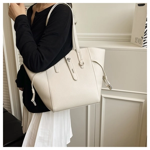 Detail of cream large tote bag featuring lychee grain texture and metal buckle lock