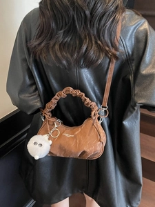 Sac croissant marron plissé avec poignée courte et bandoulière sur un mannequin