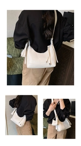 Detail view of white pebbled leather hobo bag with mini pouch and adjustable strap