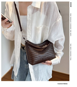 Close-up of brown woven bucket bag featuring premium leather texture and silver buckle