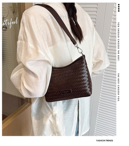 Detailed view of dark brown woven bucket bag with branded plaque and silver hardware hook