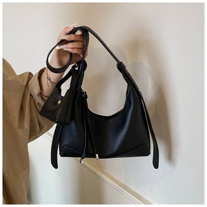 Detail of black pebbled leather hobo bag with adjustable strap and matching coin pouch