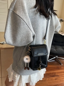 Modische schwarze Leder-Handytasche mit Plüsch-Anhänger und goldenem Metall-Detail