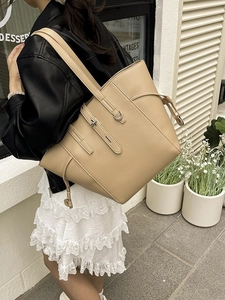 Minimalist beige lychee grain leather tote bag for women shown in an outdoor setting