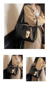Detail of black woven leather tote bag with a cute bear pendant and fringe tassel