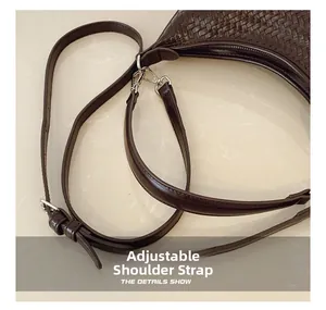 Detail view of woven brown bucket bag with adjustable strap and silver metal buckle