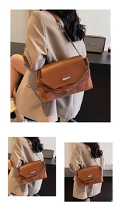Dettaglio della borsa tote in pelle e camoscio marrone con fibbia e catena
