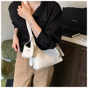 Detail of white lychee pattern leather shoulder bag with matching mini pouch and strap