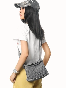 Chic grey canvas crossbody bag with unique pleated design and frayed edges for street style
