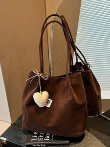 Vintage coffee suede tote bag with plush heart pendant shown in mirrored setting