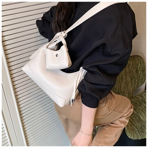 Detail view of beige lychee leather hobo bag with mini pouch on shoulder strap