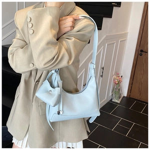 Detail of light blue lychee pattern leather shoulder bag with matching mini coin purse