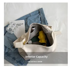 Detail view of spacious cream leather tote bag interior with umbrella and cosmetics