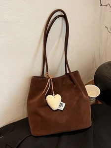 Vintage brown suede underarm bucket bag with a heart plush charm and long shoulder strap