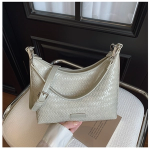 Close-up of light green woven texture bucket bag with silver hardware and brand logo