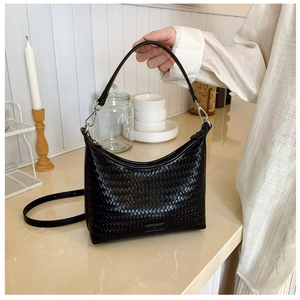 Close-up of black woven leather bucket bag with intricate intrecciato texture and handle