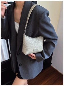 Detail of light green bucket bag featuring premium woven texture and sleek metal buckle