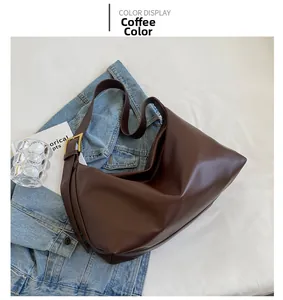 Detail of coffee brown hobo bag with matte leather texture and gold metal buckle