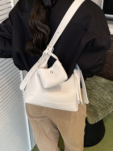 Minimalist beige hobo crossbody bag with wide strap and matching mini pouch accessory
