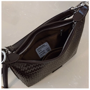 Detailed view of woven bucket bag interior with silver zipper and spacious compartments