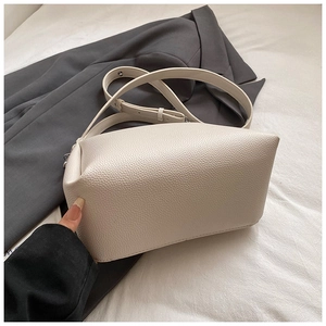 Détail d'un sac bandoulière beige en cuir grainé avec une sangle réglable élégante