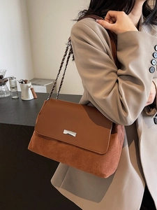 Borsa tote bicolore marrone indossata da modella in un contesto stile ufficio