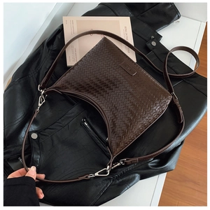 Detailed view of dark brown woven bucket bag featuring crescent shape and silver hardware