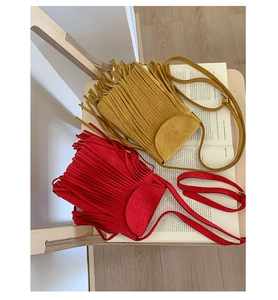 Vue détaillée de sacs à bandoulière en daim rouge et gingembre avec de longues franges