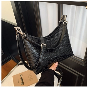 Detail of black woven bucket bag showing intricate texture and silver metal hardware