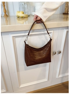 Detail of dark brown woven hobo bag with retro texture and high-capacity bucket design