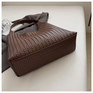 Detailed close-up of dark brown woven leather texture on a large hobo tote bag