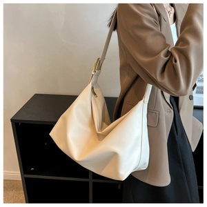 Detail of cream white leather hobo bag with gold buckle and adjustable wide strap