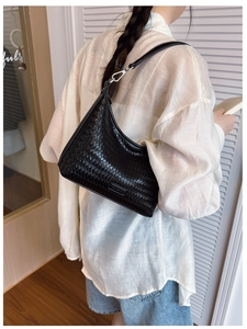 Detailed close-up of a black woven hobo bucket bag with a focus on the texture and strap