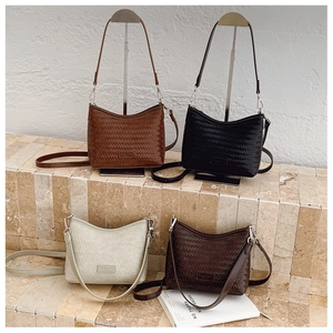 Detail of woven texture shoulder bags in brown, black, cream, and coffee PU leather