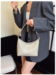 Detailed close-up of cream woven texture and silver buckle on this hobo shoulder bag