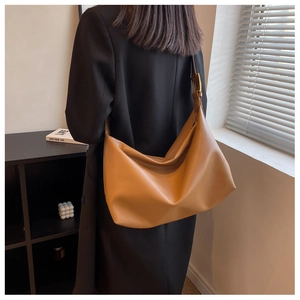 Detailed side view of brown leather shoulder bag with adjustable strap and gold hardware