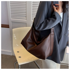 Deep brown oversized retro shoulder bag worn with a gray blazer for a stylish fall look