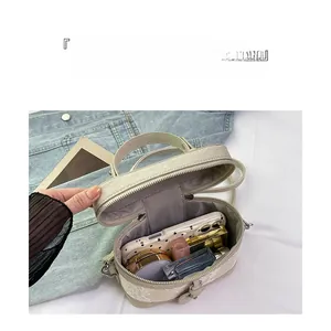 Interior view of small box bag showing organized storage for phone and cosmetics