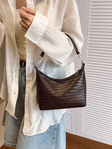 Brown woven hobo bucket bag with silver hardware for women shown in a lifestyle shot